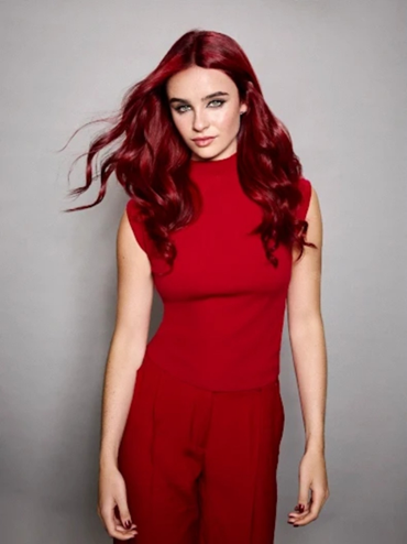 A model in a full Bold Crimson Red look, with matching hair, outfit, and nails